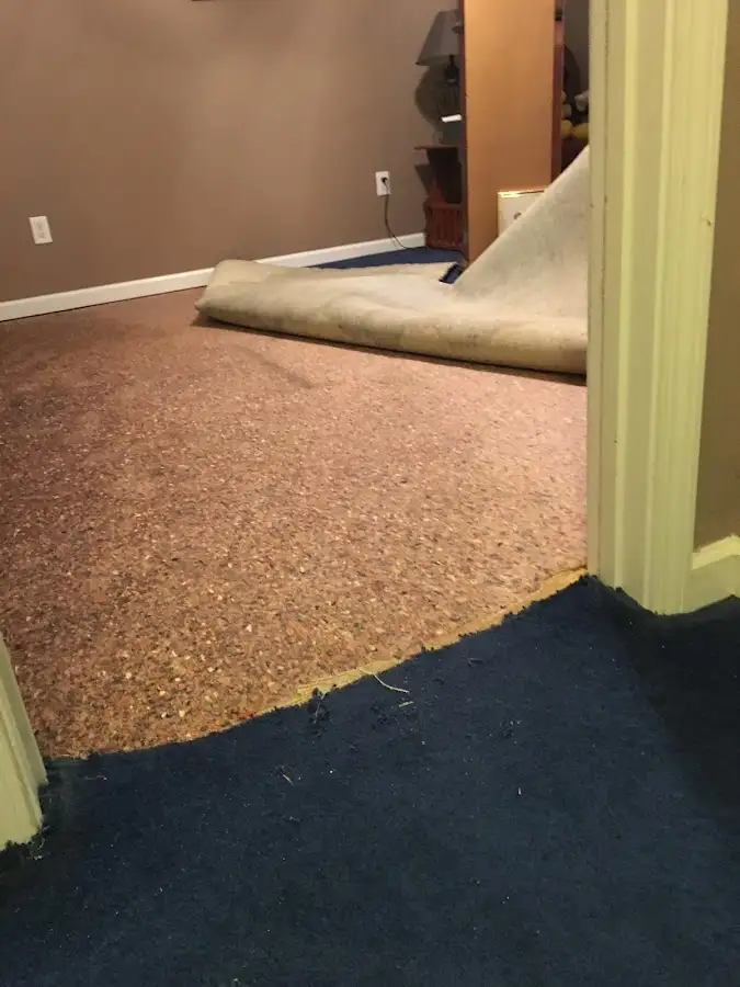 Carpet pad removal revealing water damage during Water Mitigation Services in West Hattiesburg